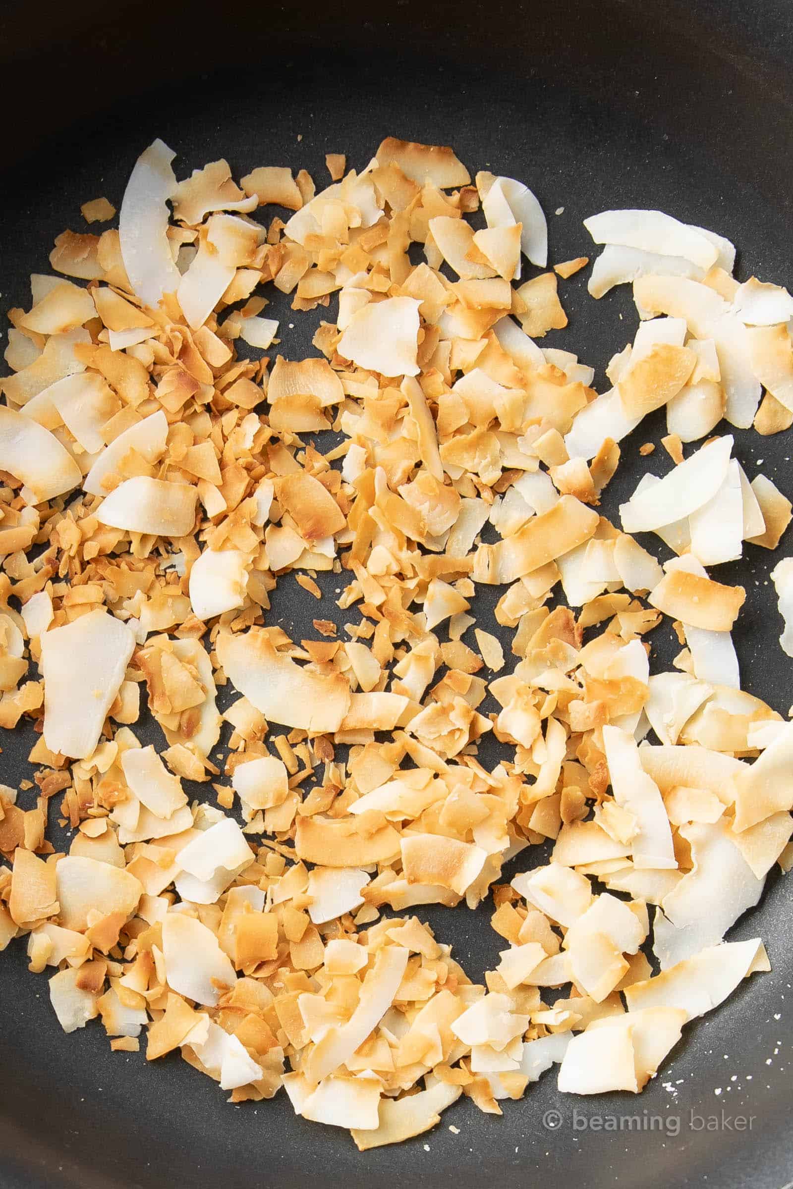 closeup shot of toasted coconut flakes with golden edges after toasting the easiest way