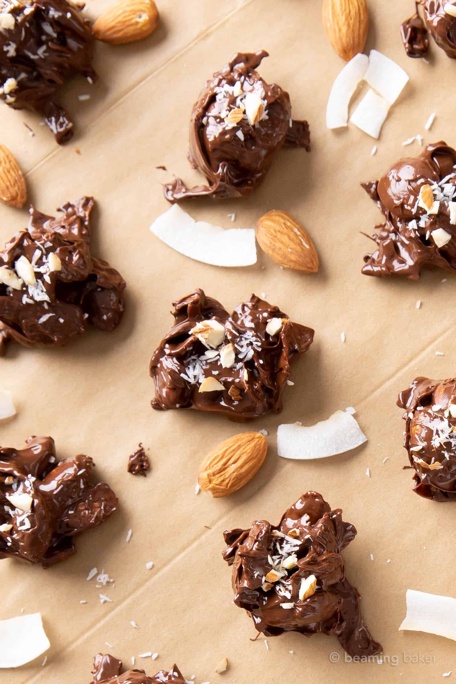 Closeup shot of dark chocolate coconut almonds on parchment paper with coconut chips and almonds