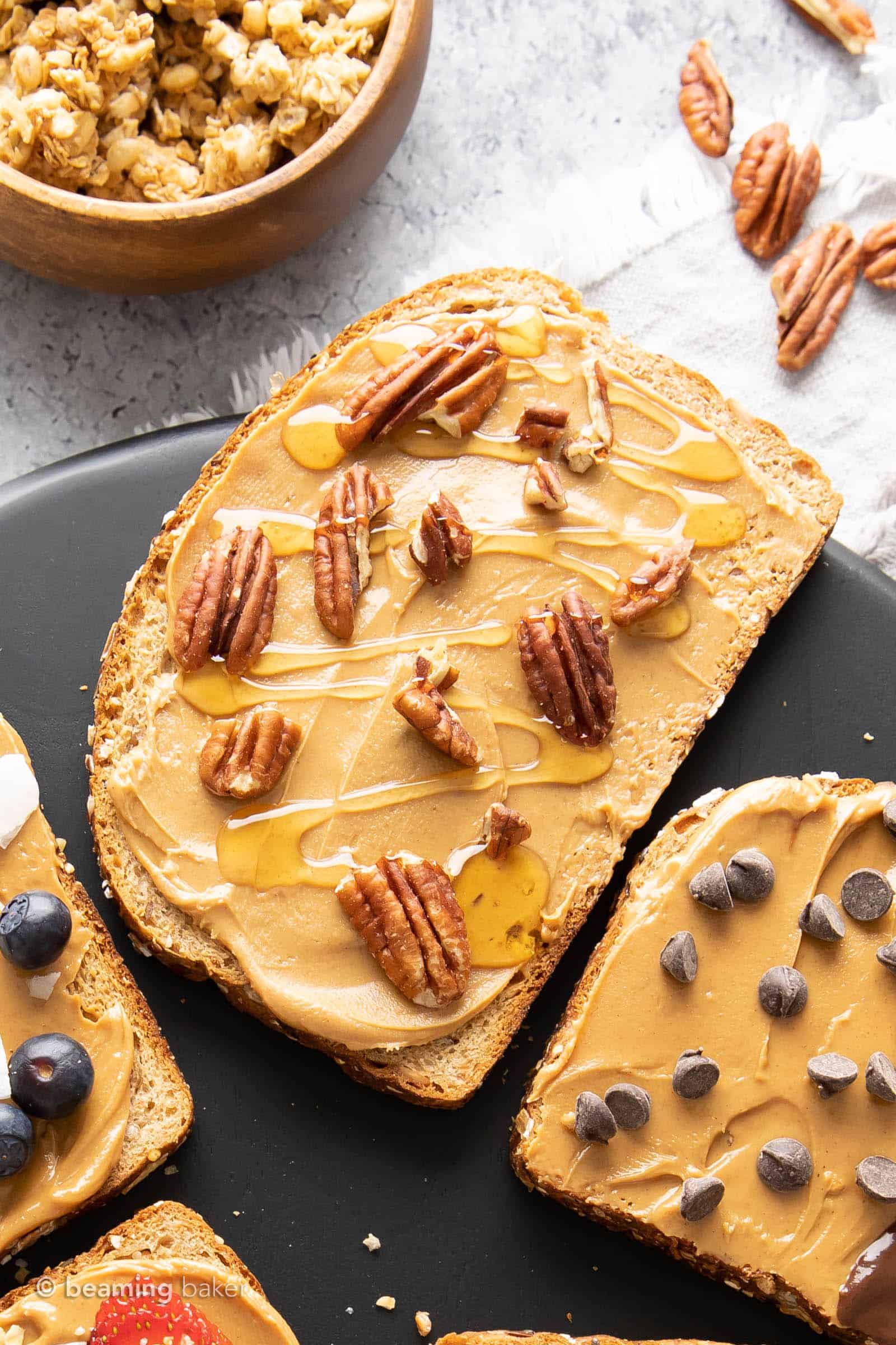 Maple pecan peanut butter toast with pecan pieces and maple syrup drizzle on top