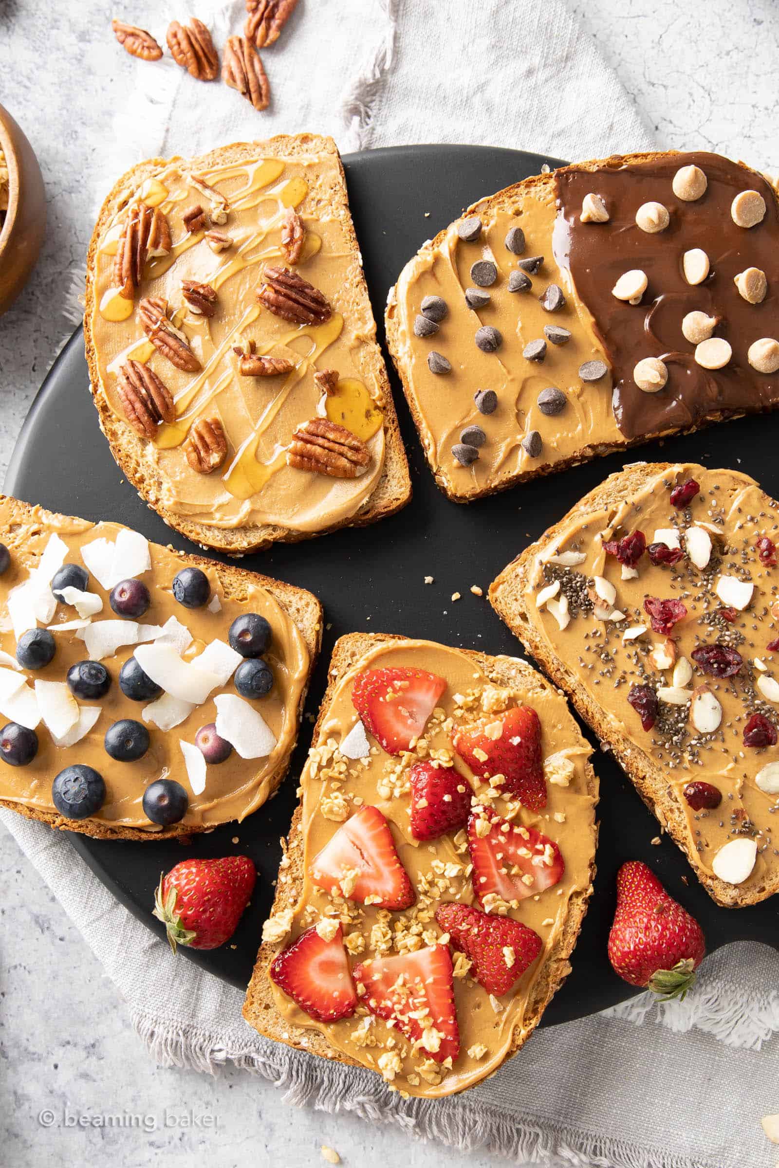 Slices of peanut butter toast covered in different toppings and spread