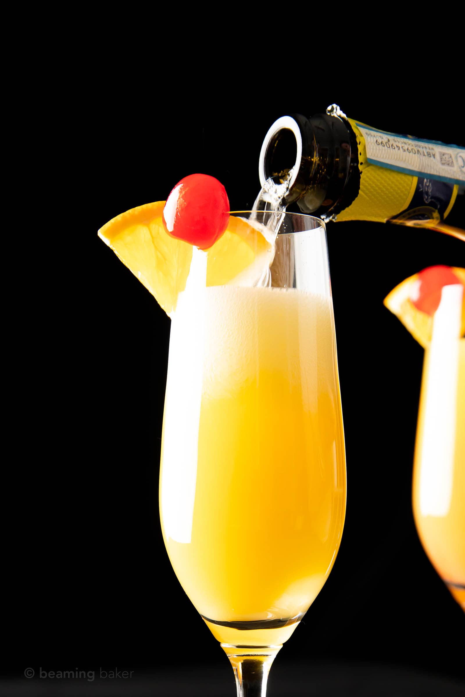 closeup pouring prosecco creating mimosa sunrise