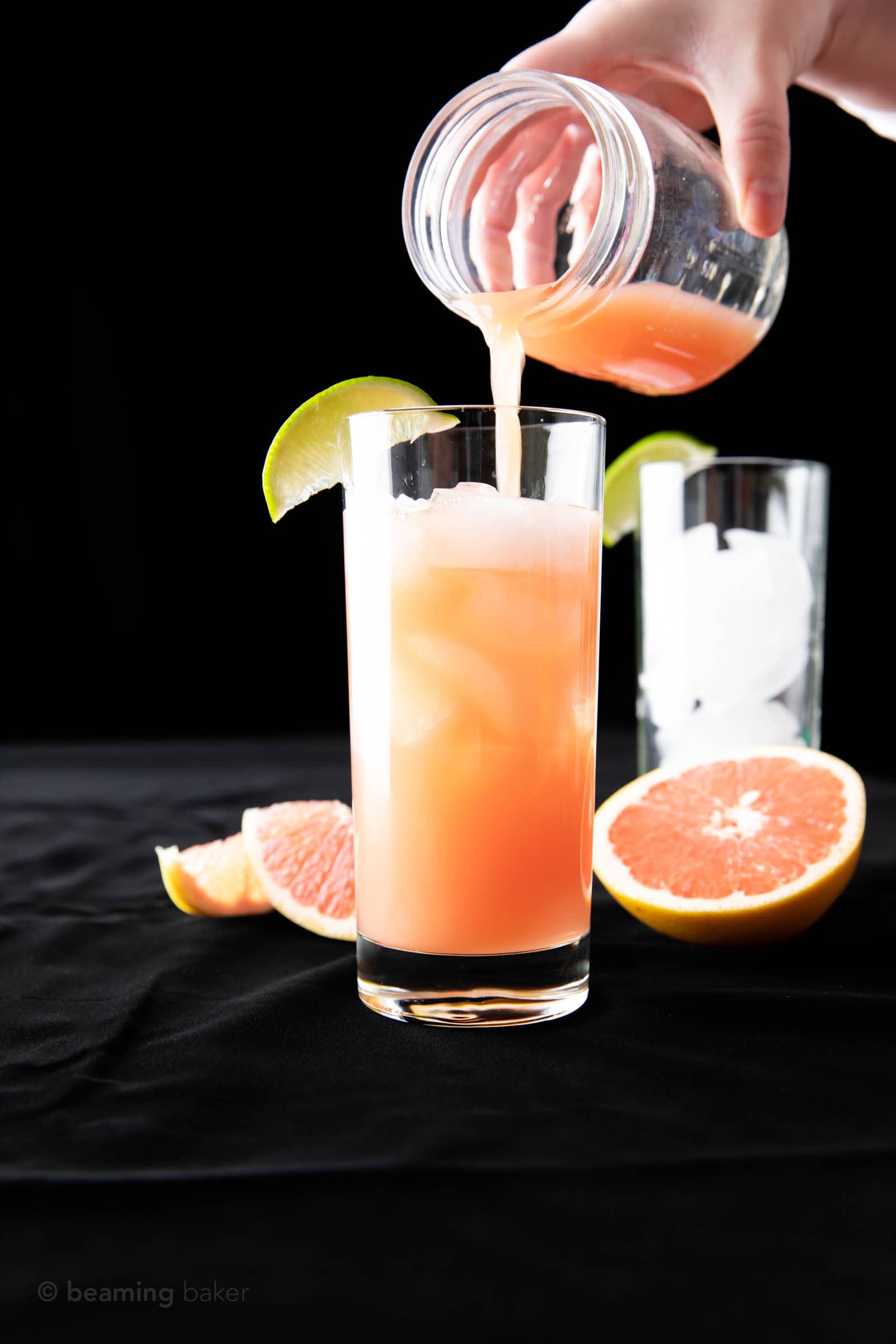 finishing the last pour of grapefruit juice into a glass to make a greyhound cocktail