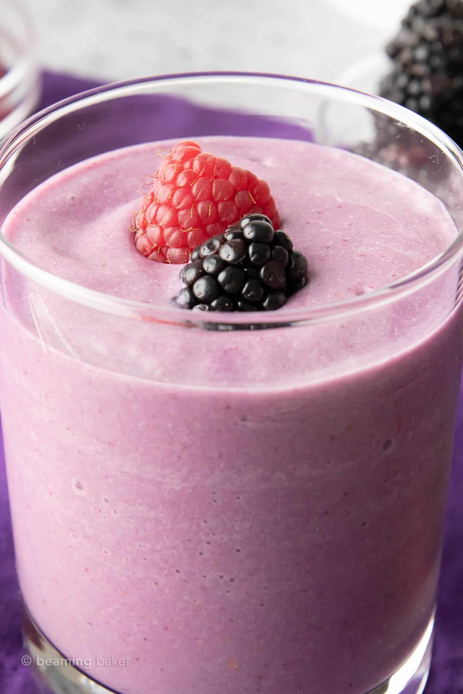 Tight shot of keto mixed berry smoothie with a raspberry and a blackberry garnish on top