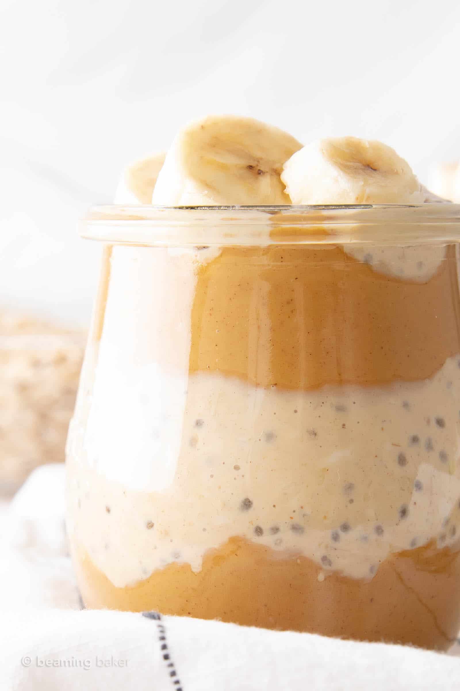 Closeup of banana peanut butter overnight oats showing layers of oats and peanut butter with banana slices on top