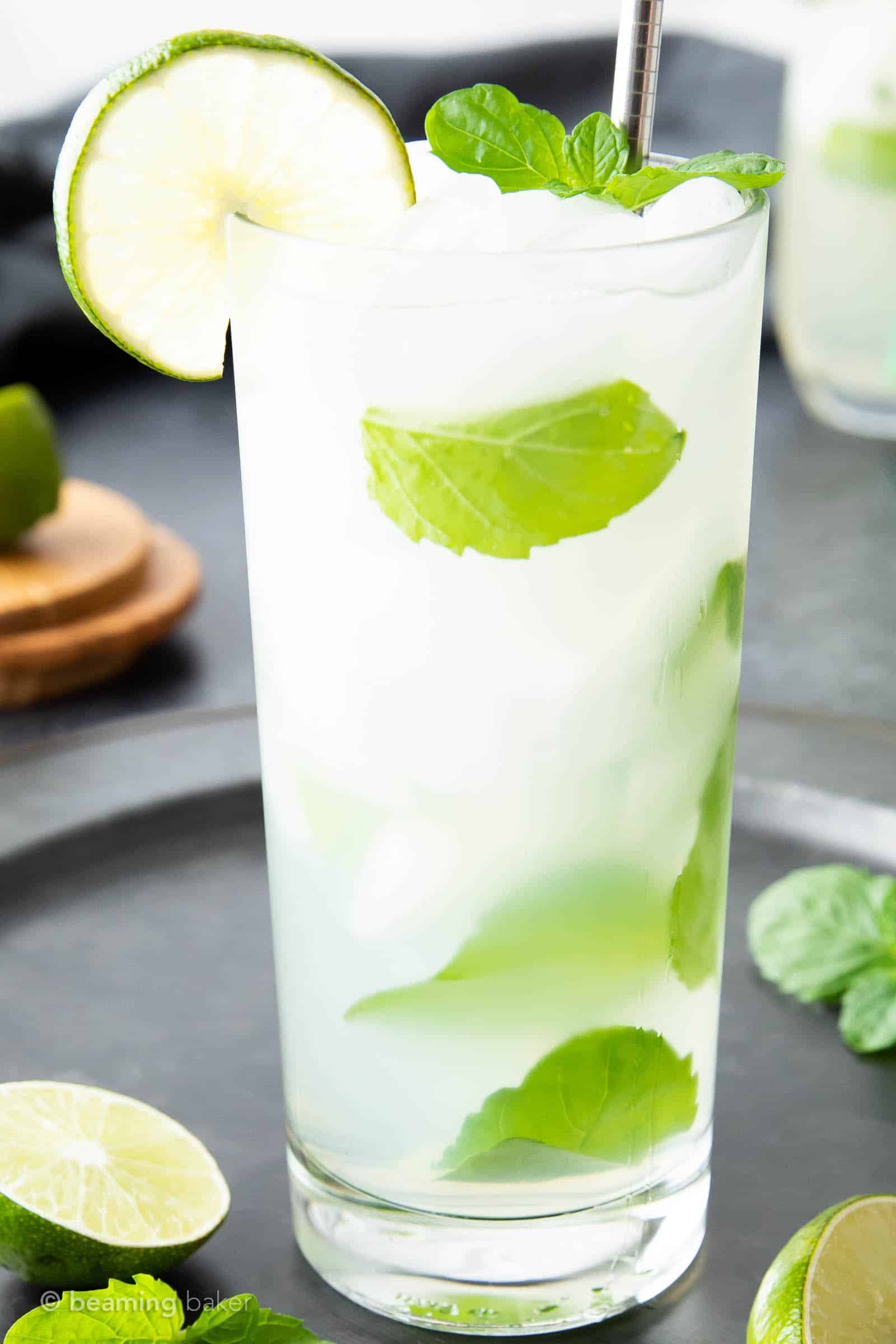 closeup of a mojito drink on a serving track with cocktail accessories