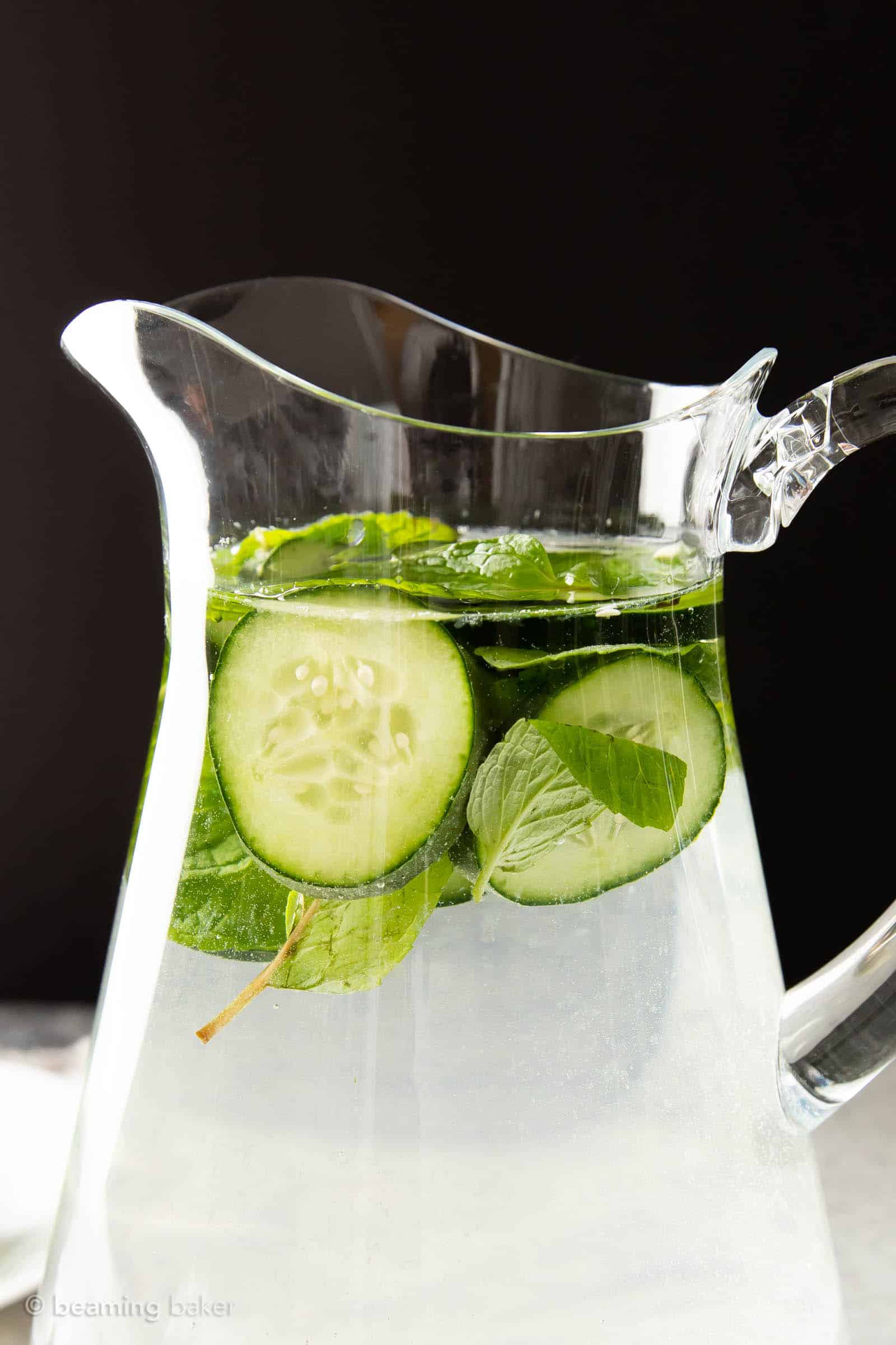 Top of a pitcher of cucumber mint water in front of a black background