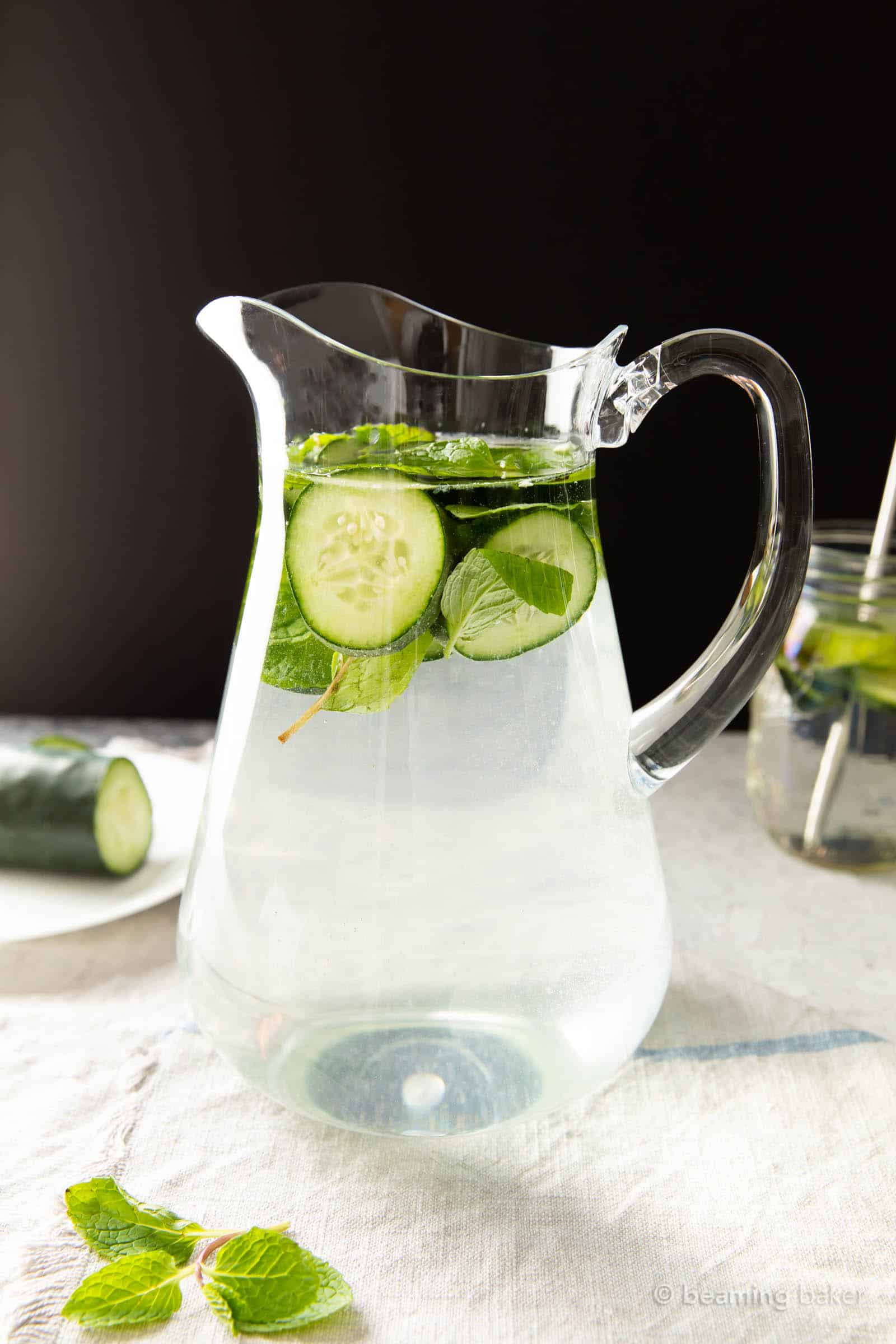 Pitcher of detoxifying beverage against a black backdrop