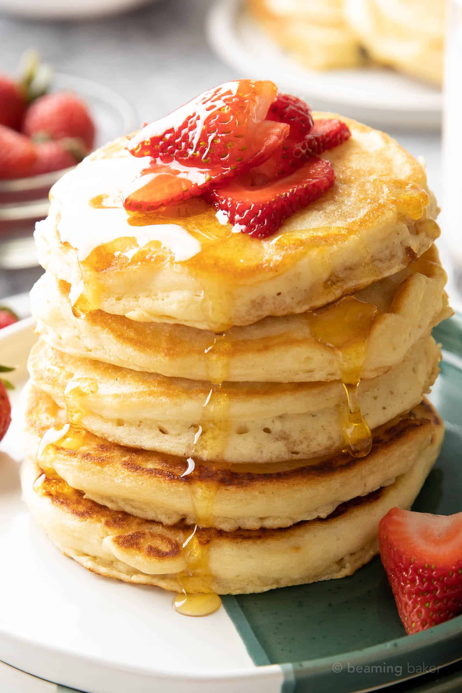 closeup shot of easy strawberry pancakes drizzled in maple syrup