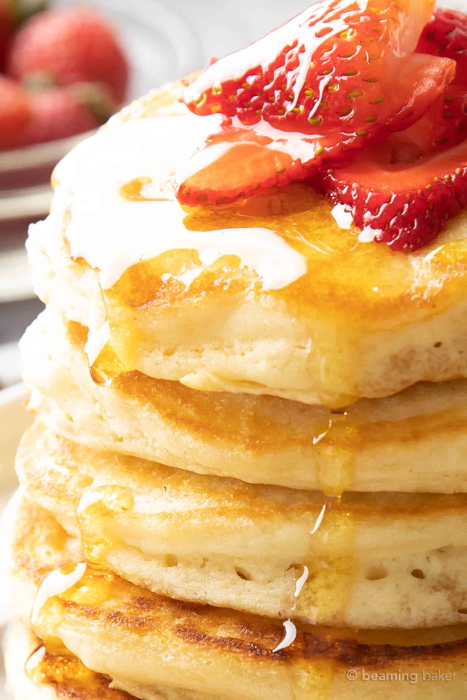 angled super close shot of pure maple syrup running down a stack of easy strawberry pancakes
