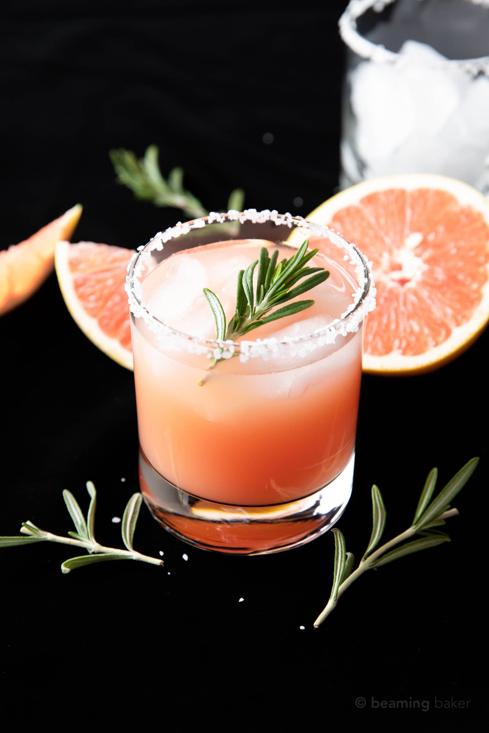 closeup shot of finished salty dog drink recipe in a rocks glass with fresh grapefruit slices and rosemary