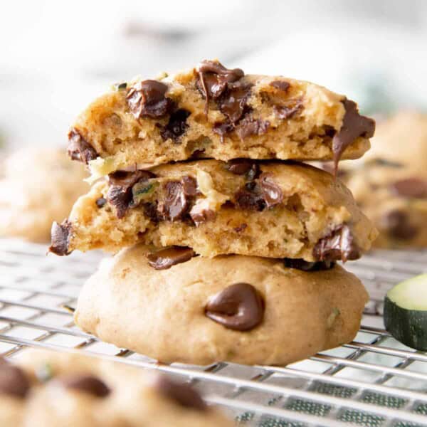 Stack of three zucchini chocolate chip cookies on a cooling rack