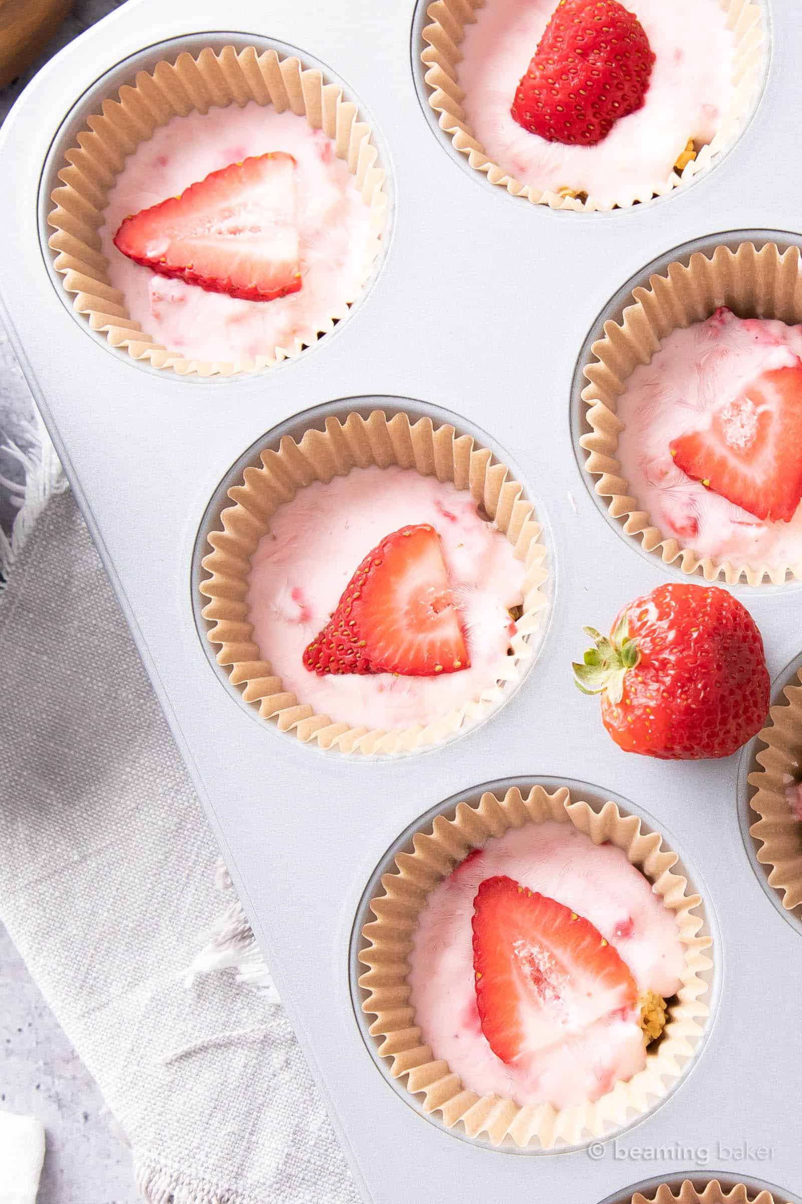very close shot of three strawberry yogurt bites with strawberry slices and whole strawberries