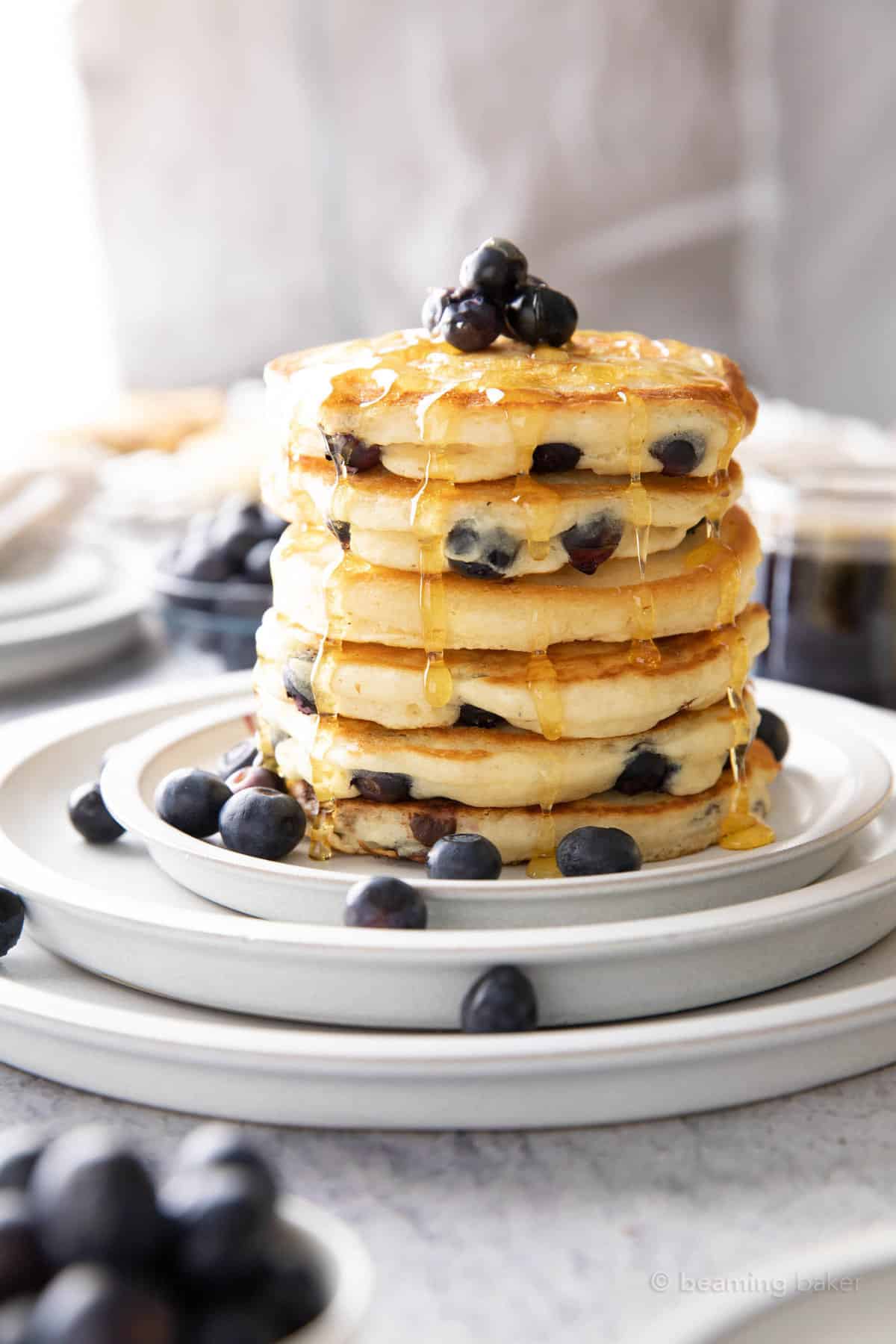 The vegan blueberry pancake recipe on a plate with fresh blueberries