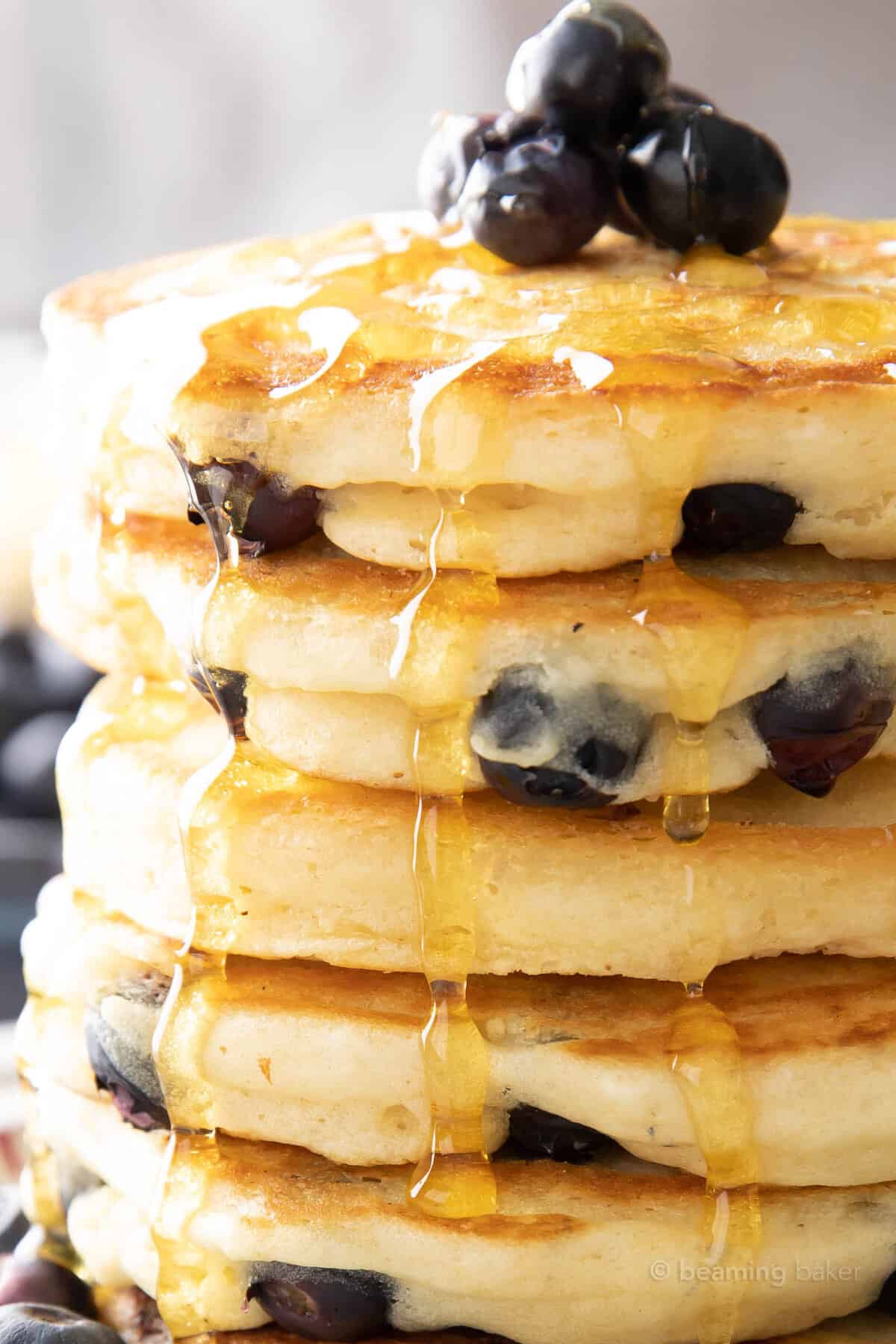 Super closeup shot of pancake syrup dripping down blueberry pancakes vegan