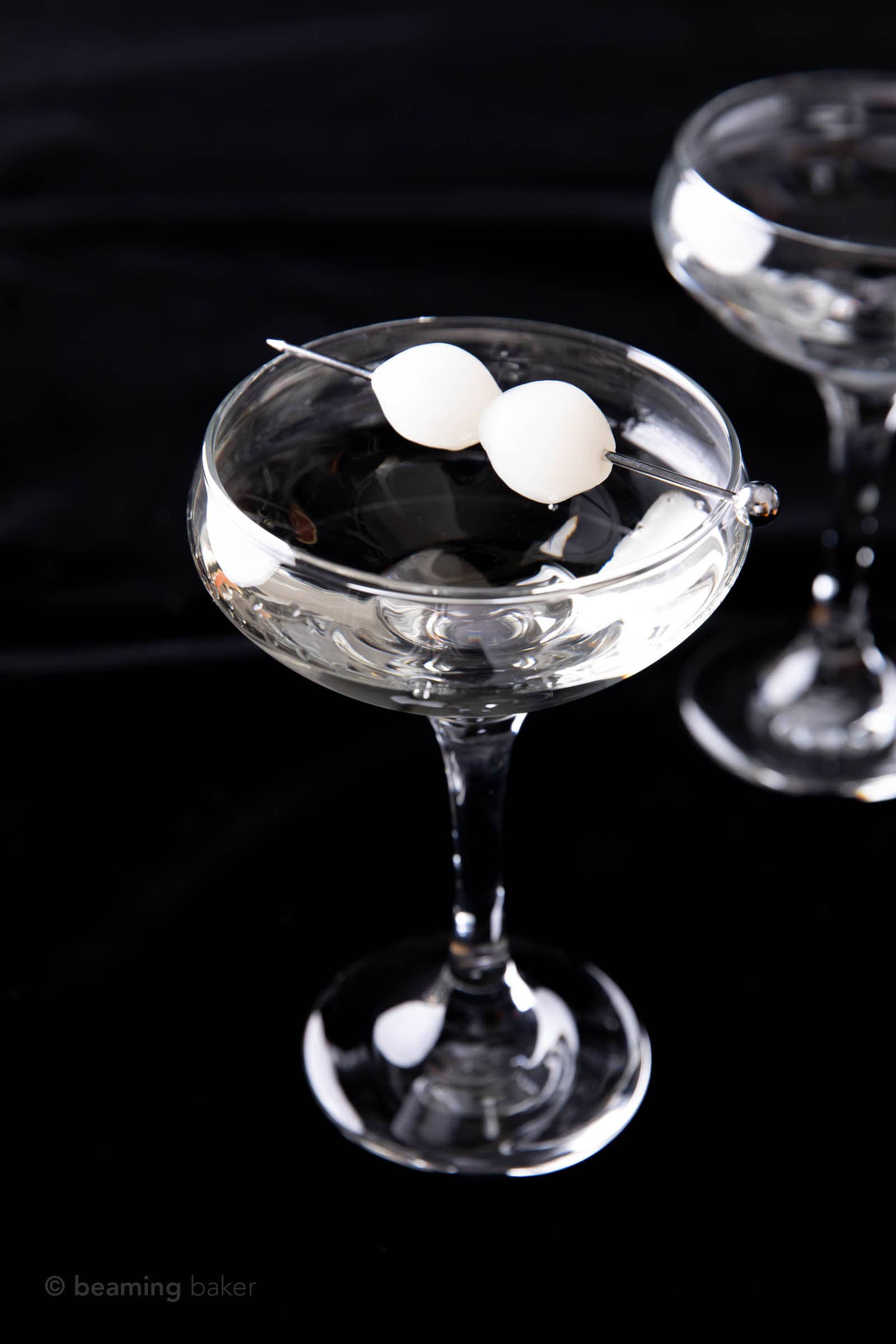 two gibson drinks in glasses against a black backdrop