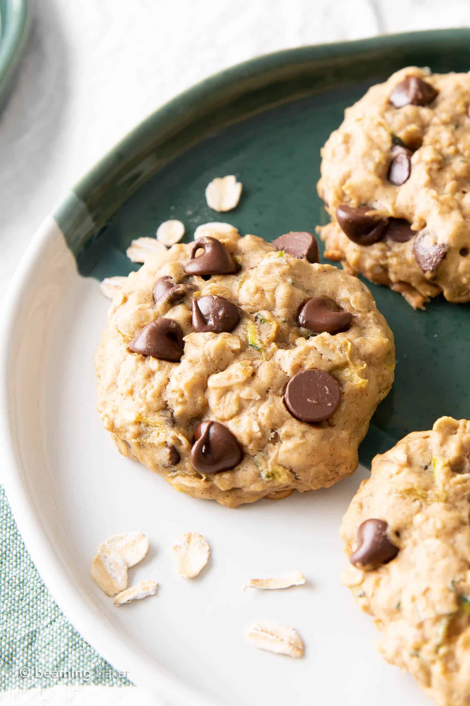 One zucchini oatmeal chocolate chip cookie close up on a plate with oats
