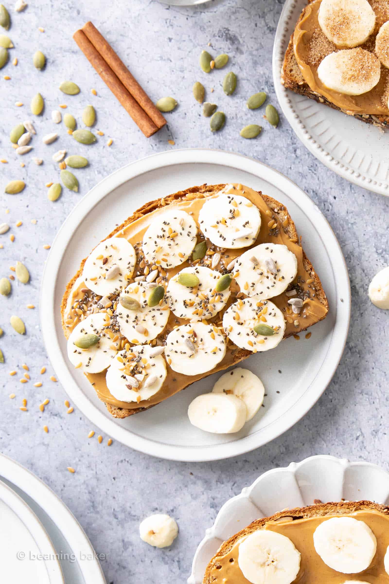 plate of peanut butter banana toast topped with seeds