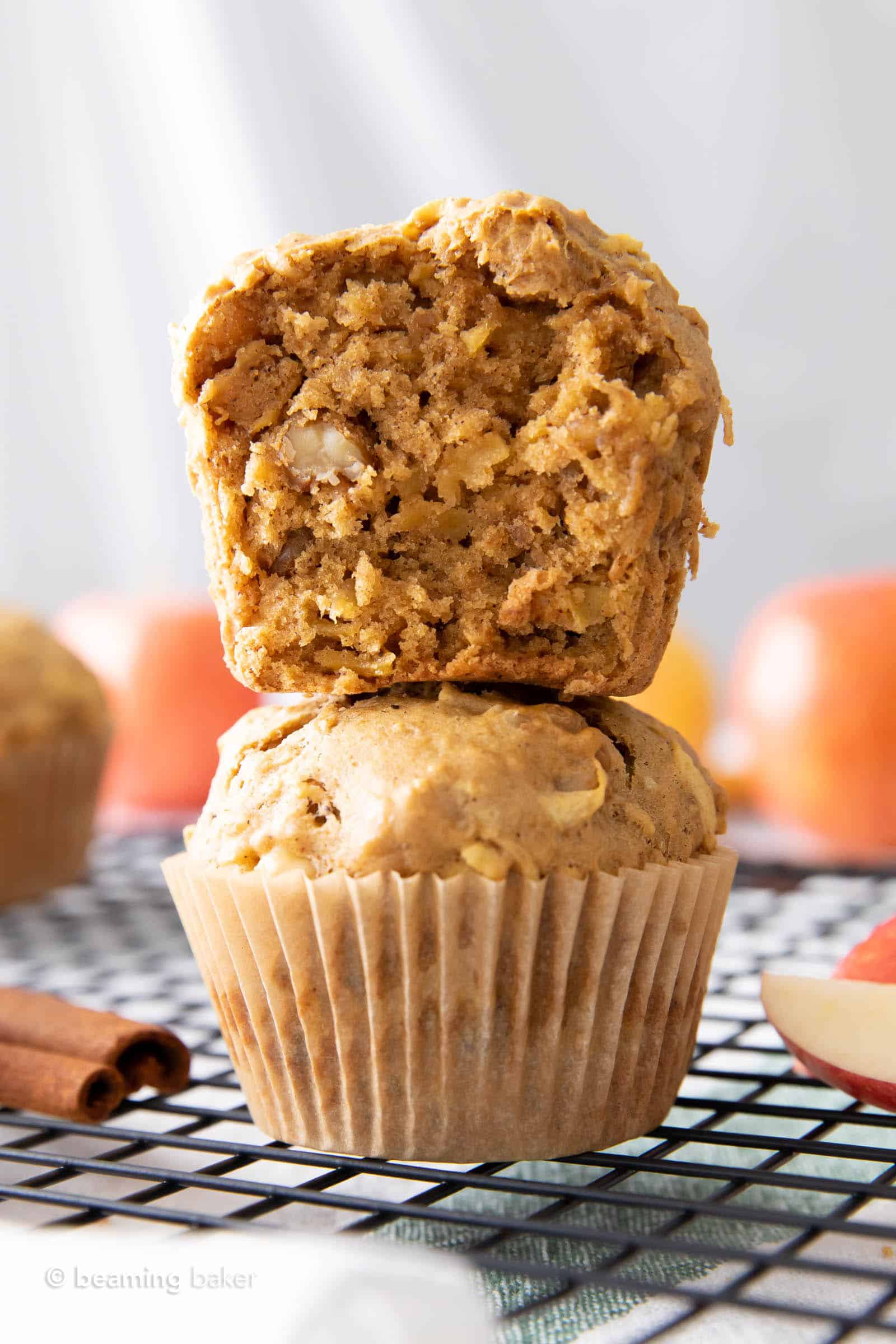 Stack of two vegan apple muffins, one half muffin on top of a full muffin