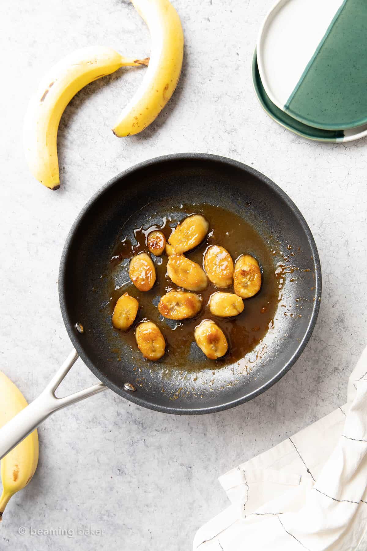 cooking bananas in a medium nonstick skillet with two bananas on the side
