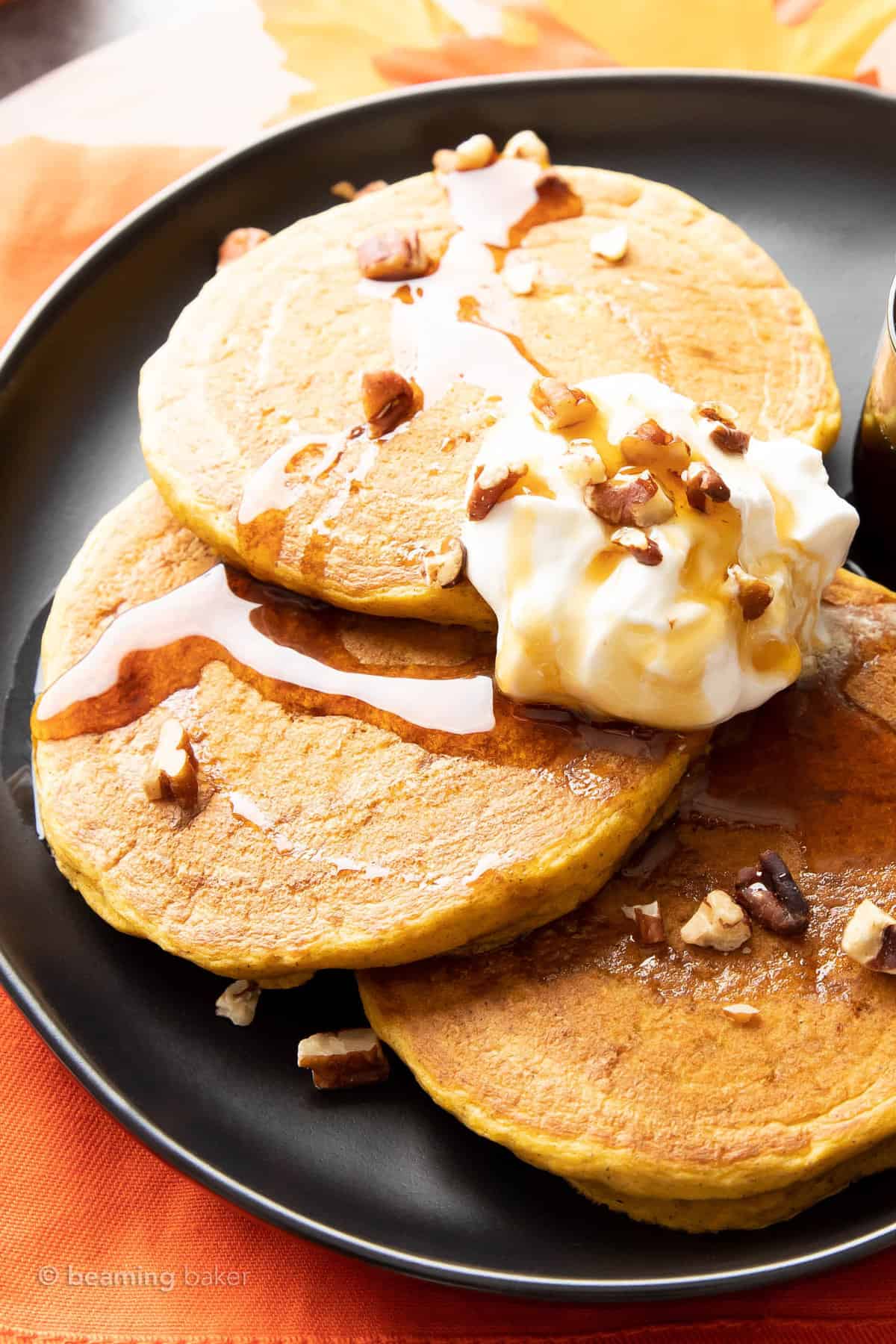 Three pumpkin spice pancakes on a black plate