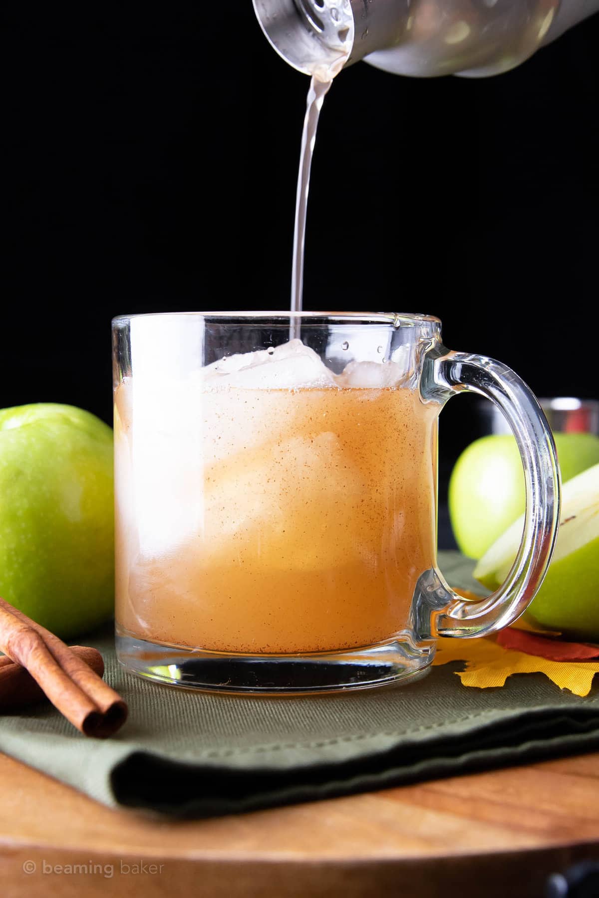 pouring the last drop of apple juice cocktail from the shaker into the glass