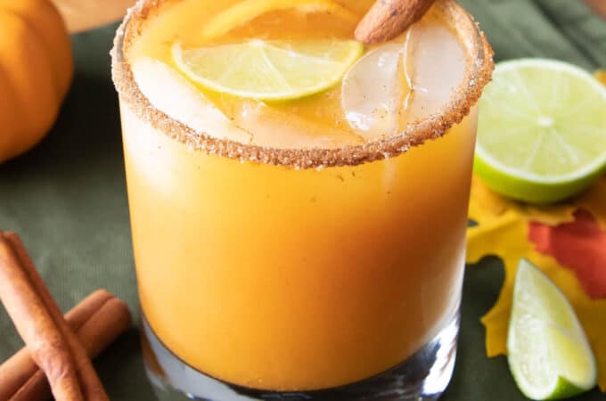 a pumpkin cocktail in a glass with a cinnamon stick