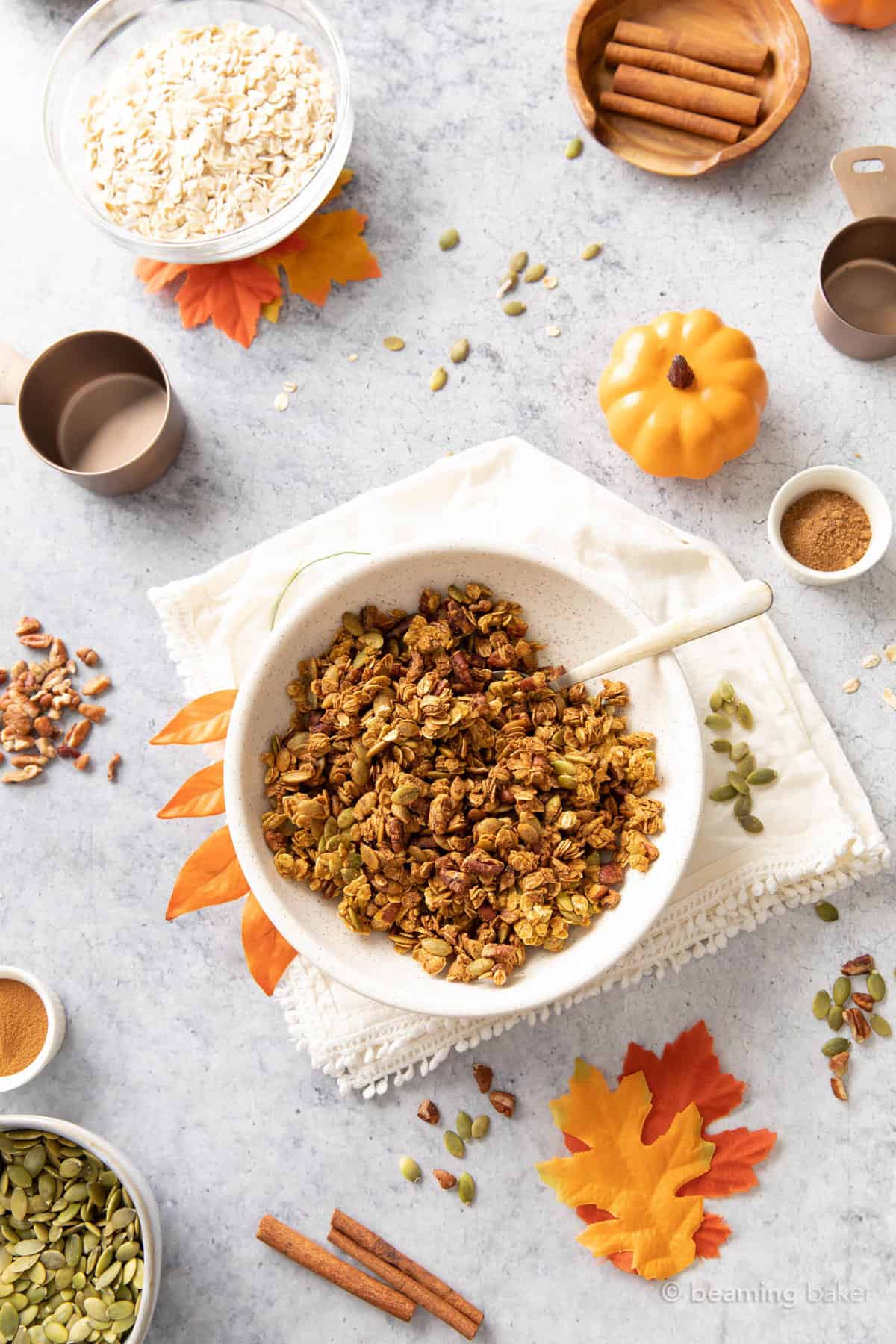 breakfast table with pumpkin granola, ground cinnamon, pumpkins, and fall decor.