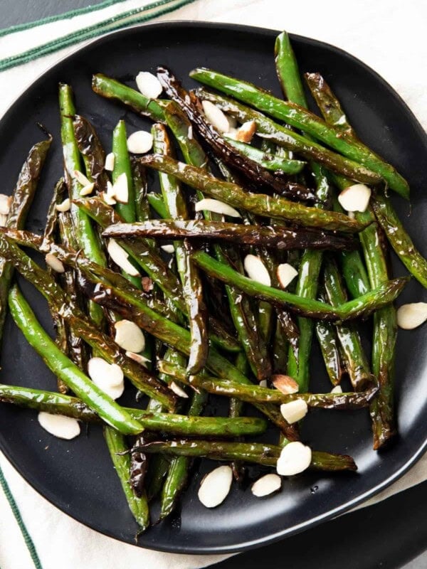 closeup photo of blistered green beans with almonds on top