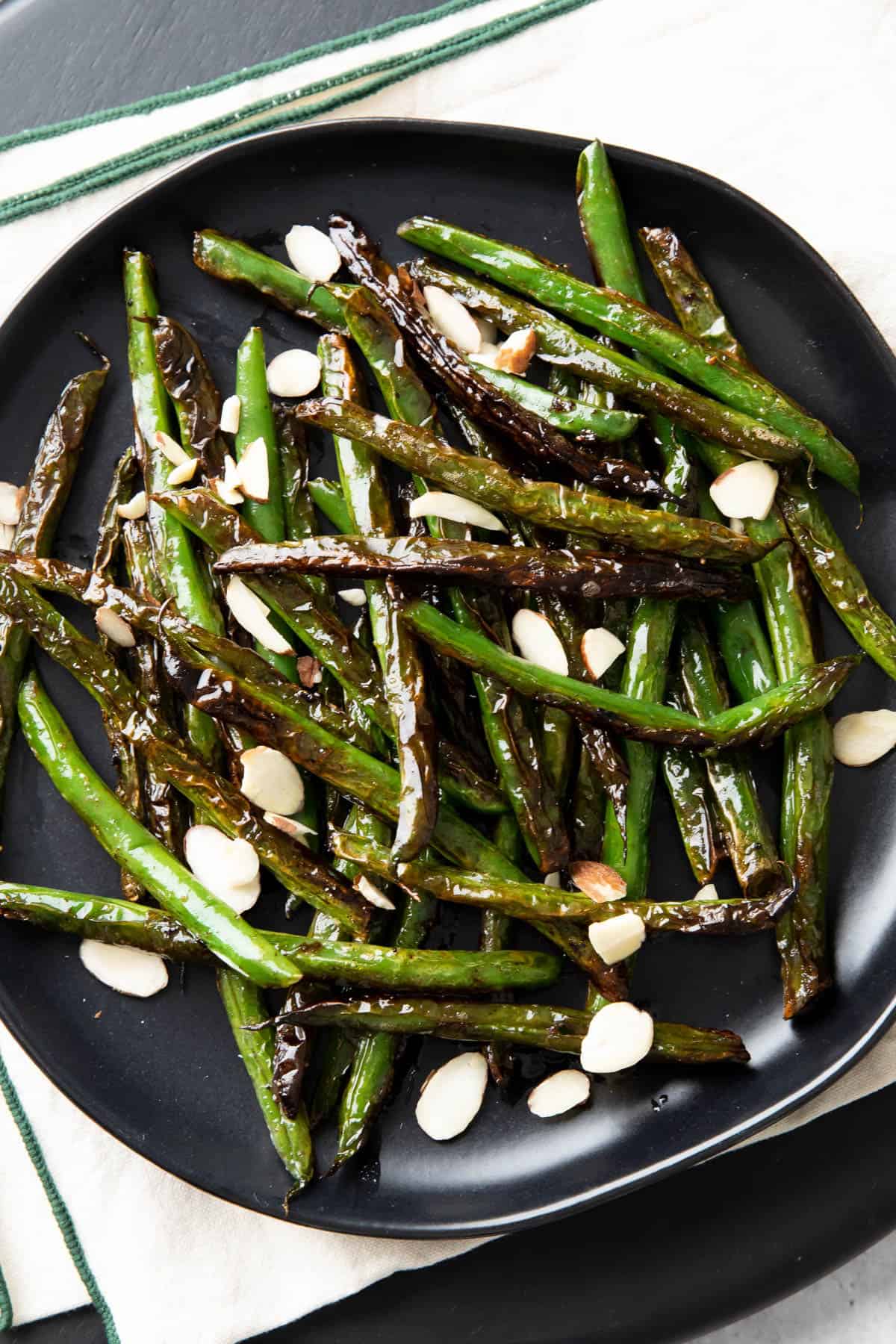 closeup photo of blistered green beans with almonds on top