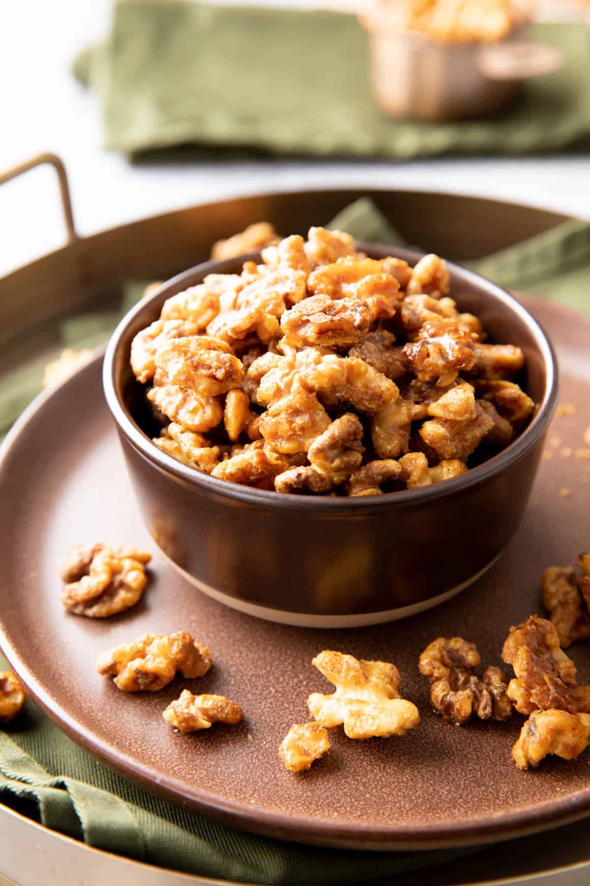 a bowl of Candied Walnuts on a plate