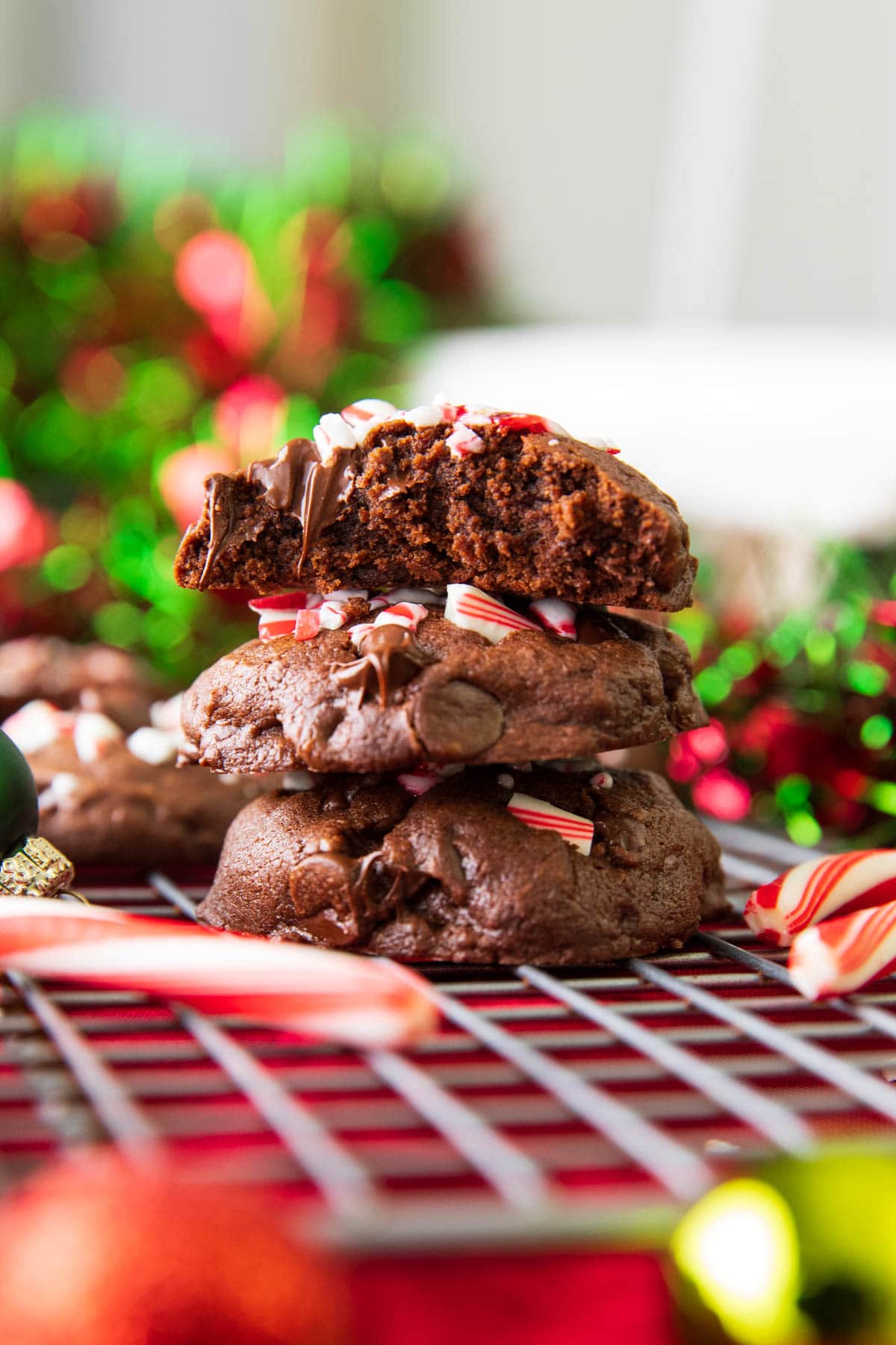 Stack of double chocolate peppermint cookies with one bitten and peppermint chocolate chips melting