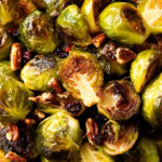 Close up of maple glazed brussel sprouts recipe shows crisped edges, sweet glaze, and delicious add-ins like bacon sprinkled on top