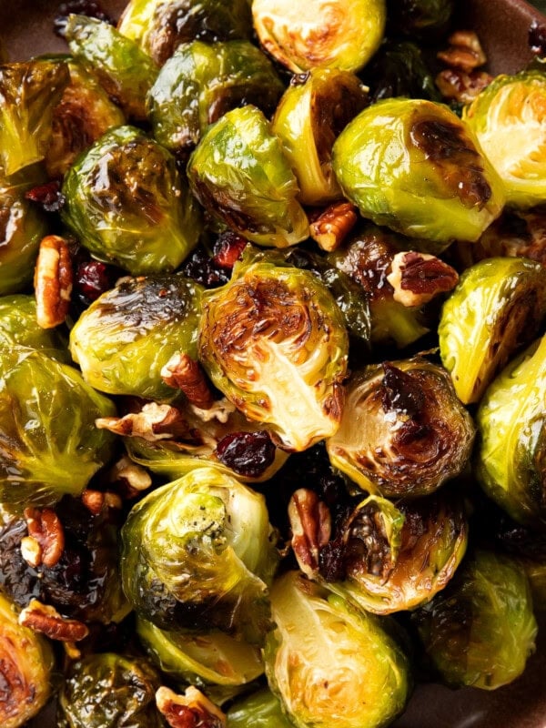 Close up of maple glazed brussel sprouts recipe shows crisped edges, sweet glaze, and delicious add-ins like bacon sprinkled on top
