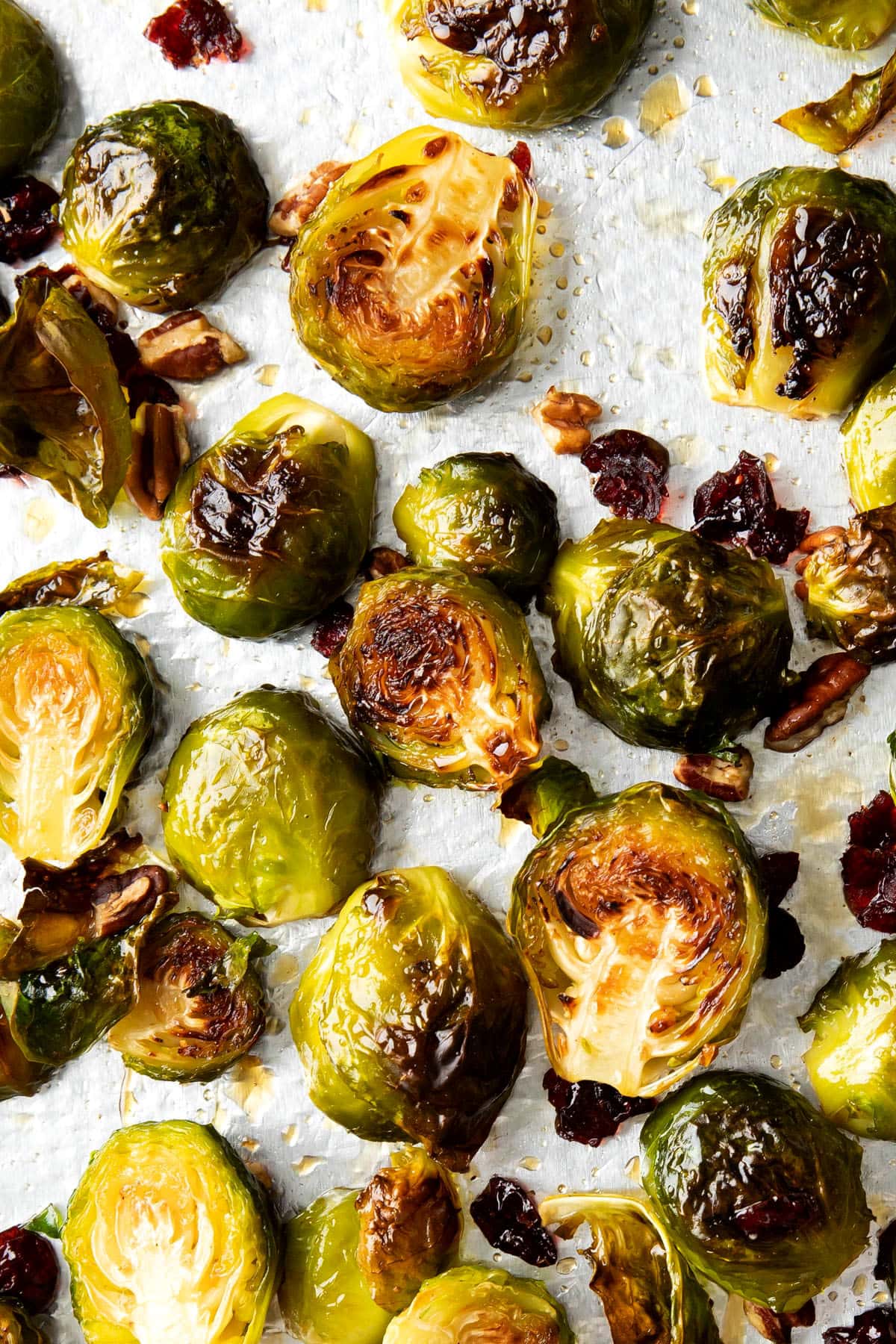 Brussel sprouts and maple syrup recipe shown baked on a lined baking sheet.