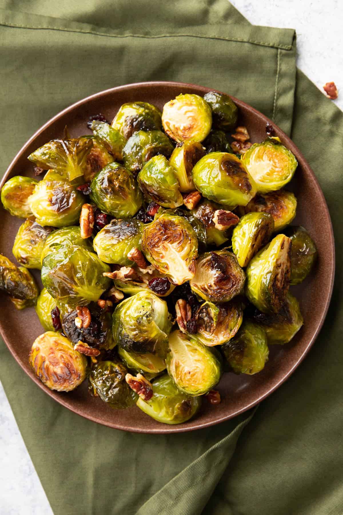 brown plate of maple Brussels sprouts on a green cloth