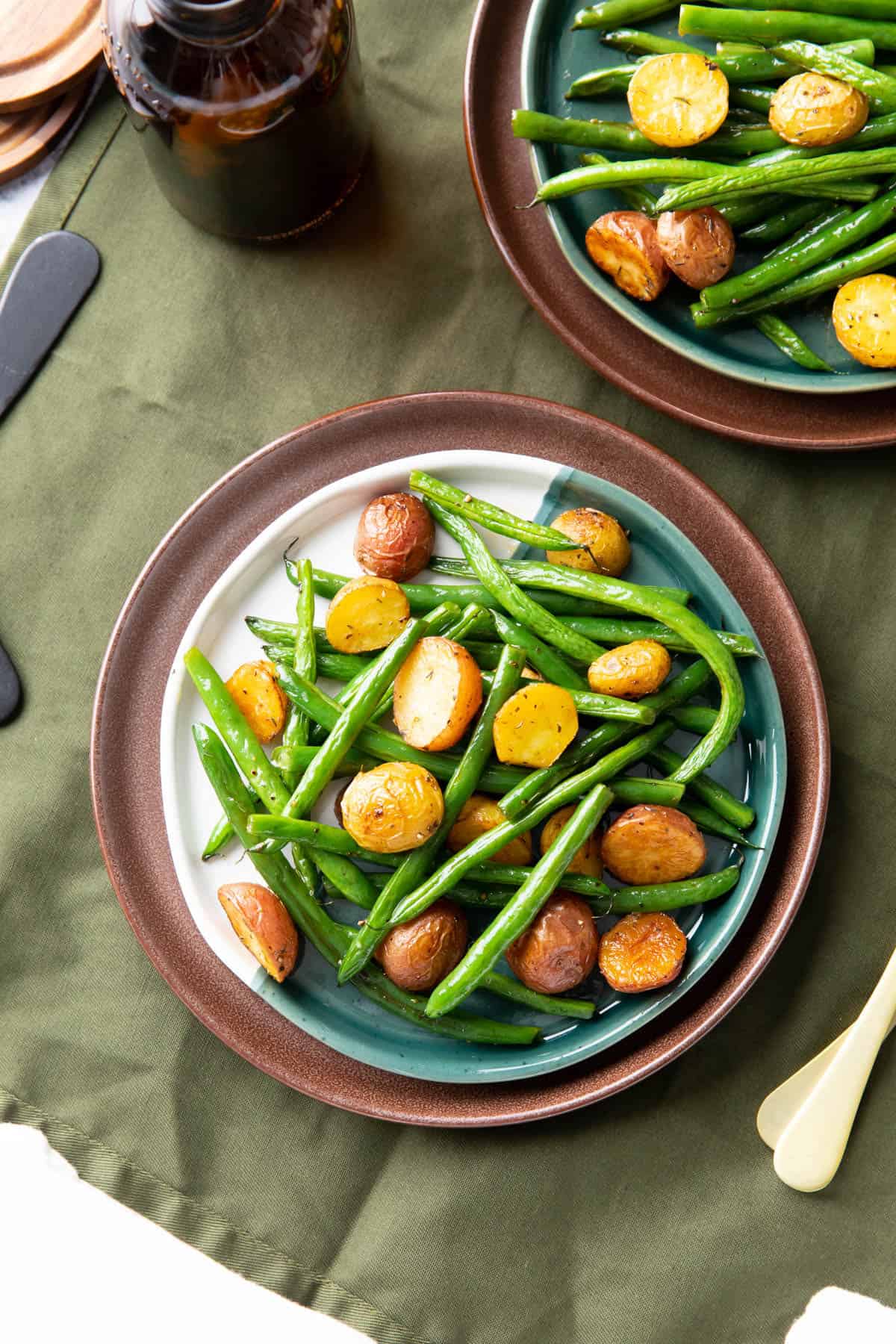 dining table with plated roasted green beans and potatoes