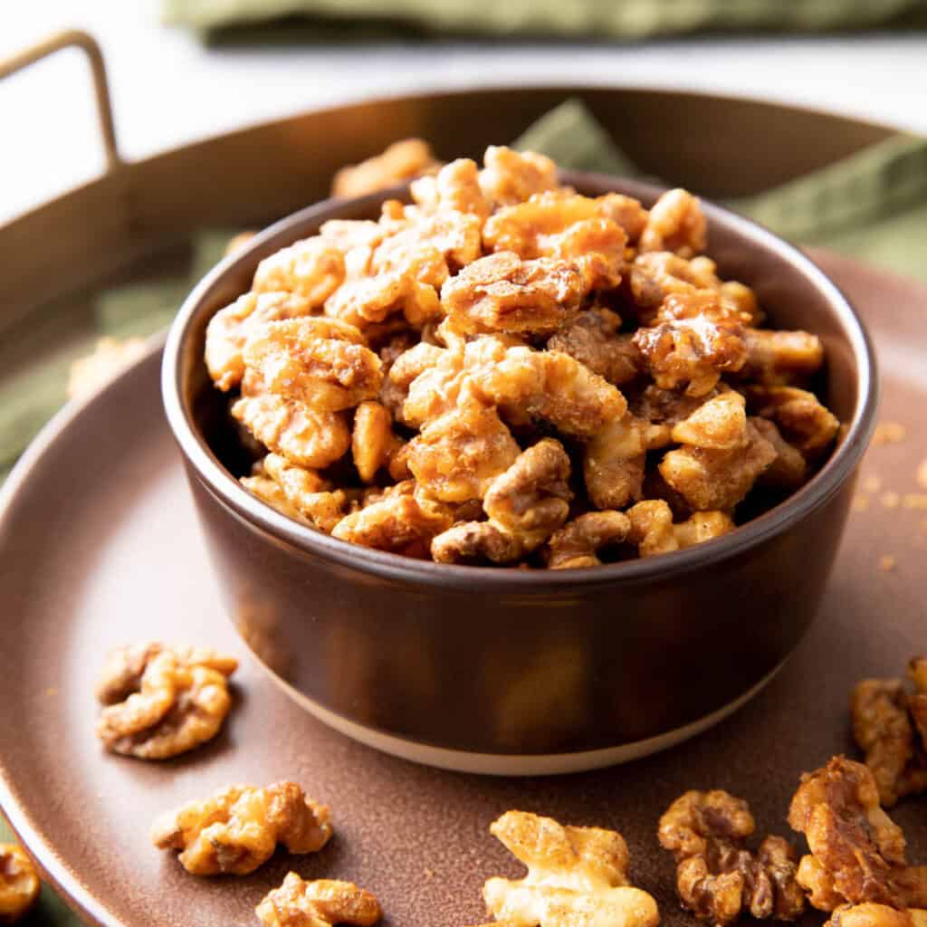 square photo of candied walnuts in a bowl
