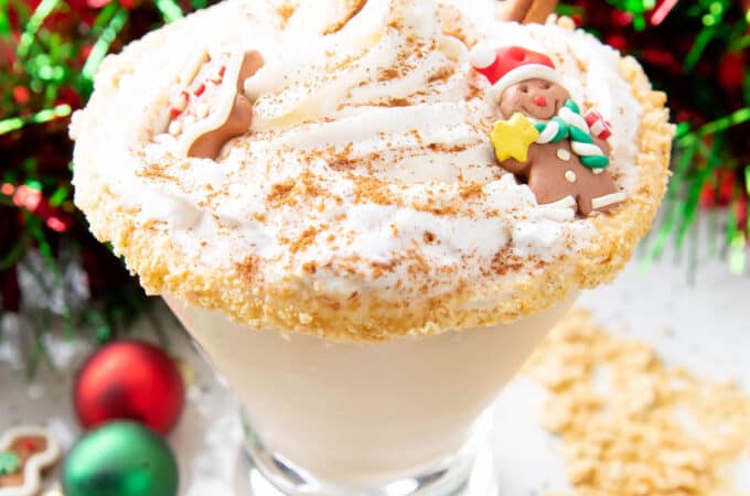 a gingerbread martini topped with whipped cream and gingerbread cookies