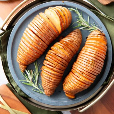 dinner table with Hasselback Sweet Potatoes on a serving tray