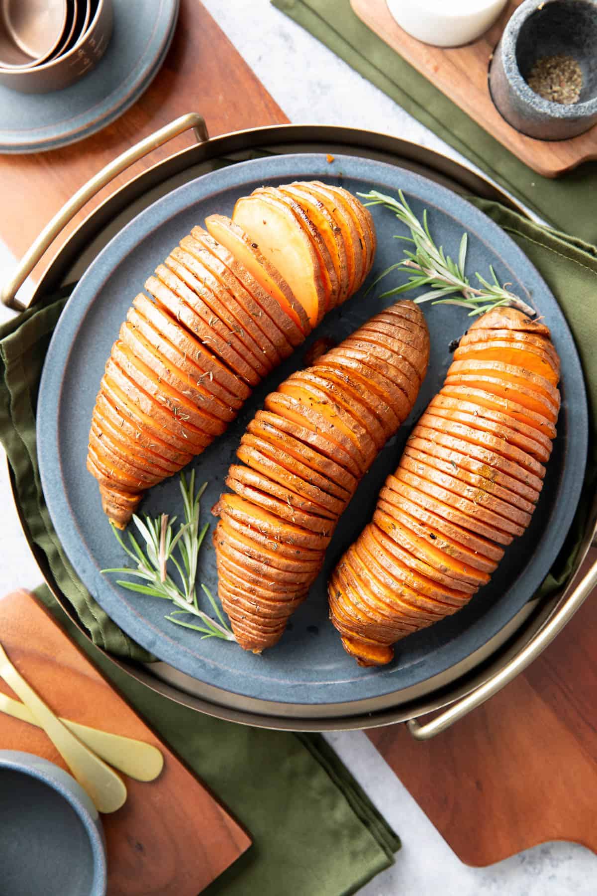 dinner table with Hasselback Sweet Potatoes on a serving tray
