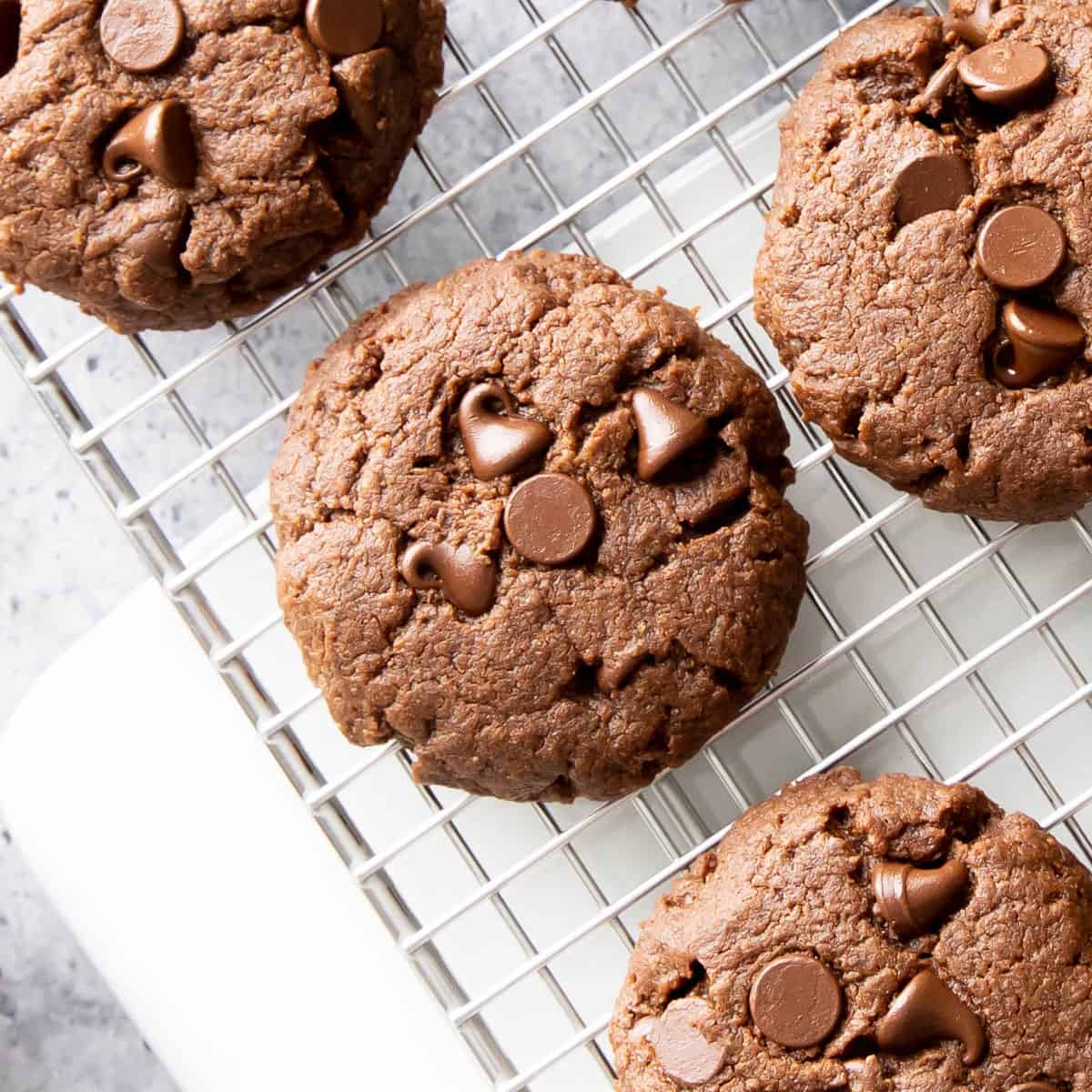 closeup photo of dark chocolate cookies on a silver cooling rack 