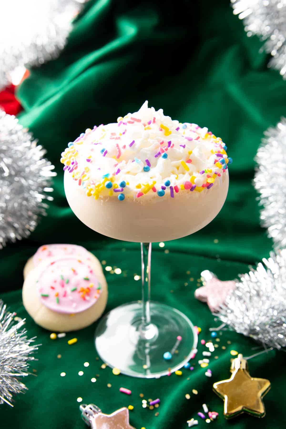 Sugar cookie martini with sugar cookies on a green background