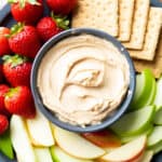square photo of peanut butter dip served with fruits