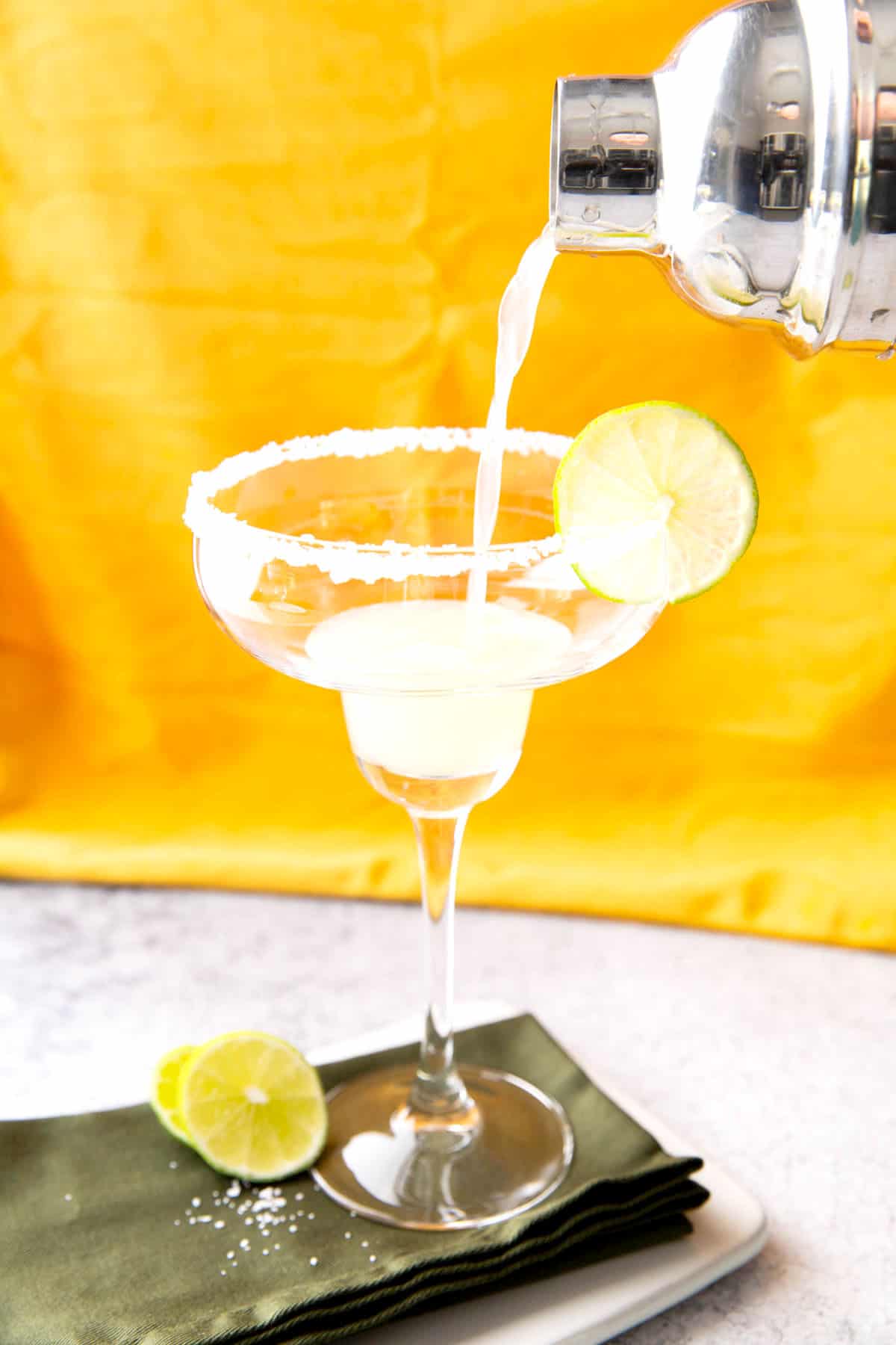 Photo showing How to Make a Cadillac Margarita – straining cocktail mixture into glass 