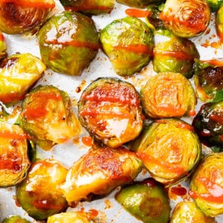closeup photo of honey sriracha Brussels sprouts on a foil-lined tray
