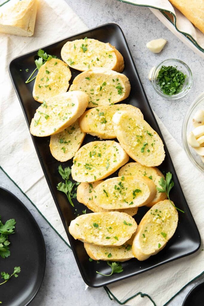 garlic toast served with garnish, lots of garlic oil and salt