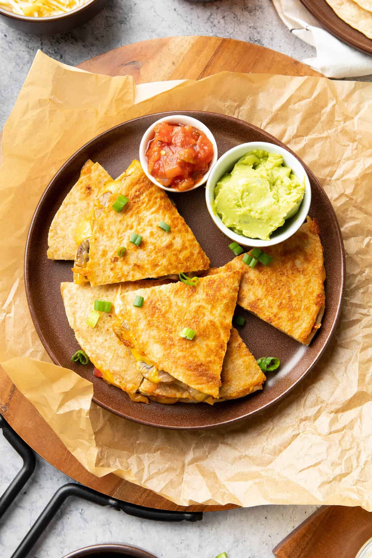 Mushroom quesadilla on a brown serving plate with salsa