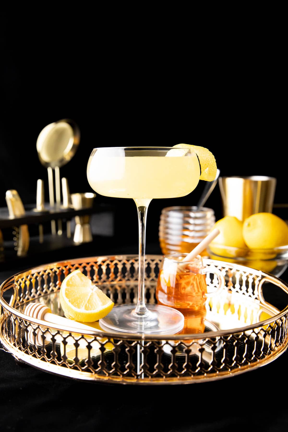 This cocktail recipe served on a tray with lemon and honey