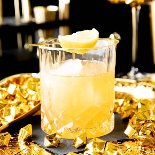 Gold Rush Cocktail served in an old fashioned glass with a lemon garnish