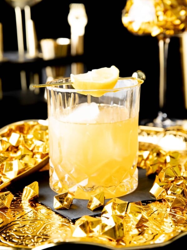 Gold Rush Cocktail served in an old fashioned glass with a lemon garnish